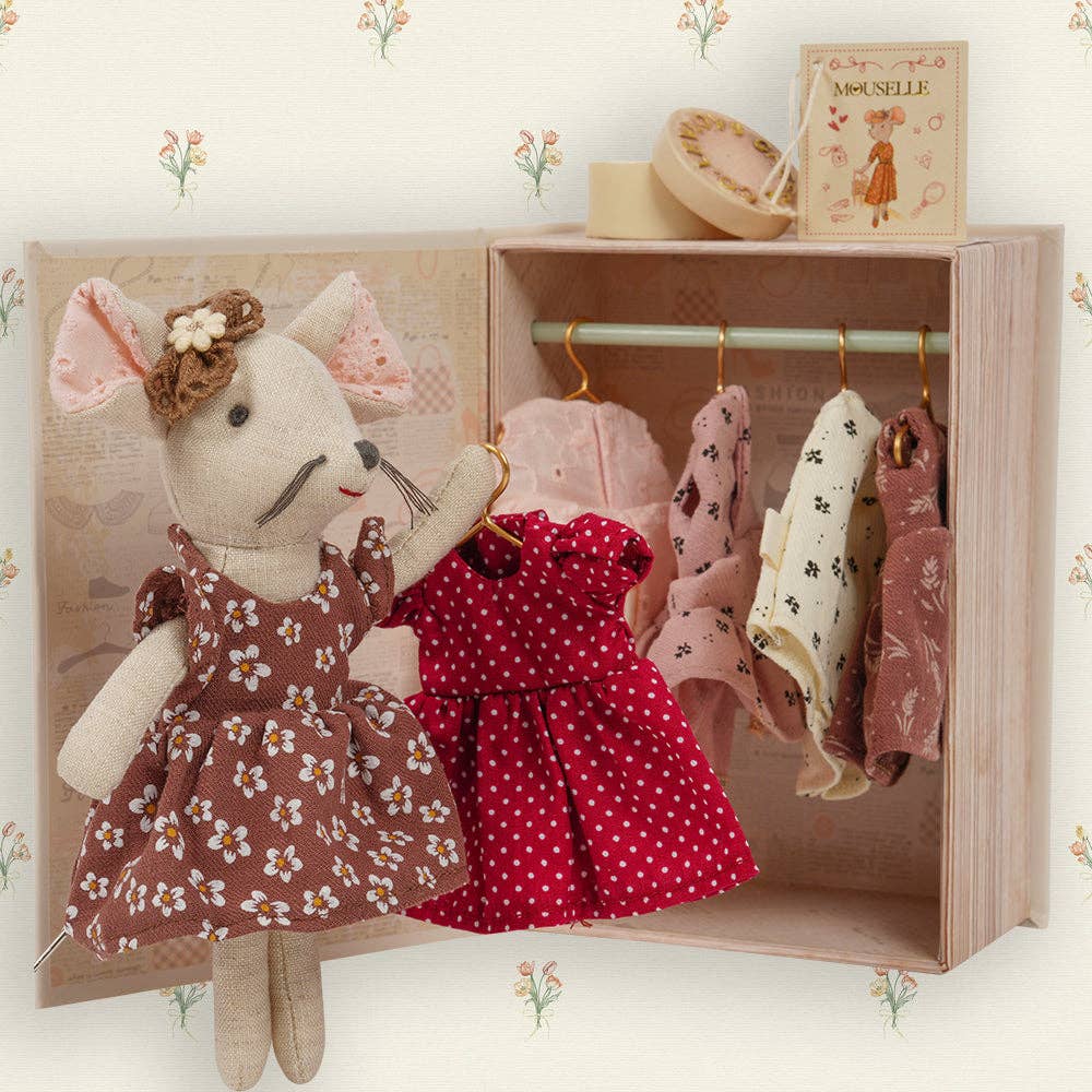 Toy mouse with dresses in a wooden wardrobe with floral wallpaper.