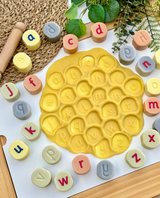 Alphabet stamping stones used with yellow playdough