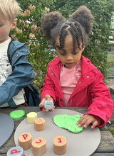Children using alphabet stamping stones for phonics and word building