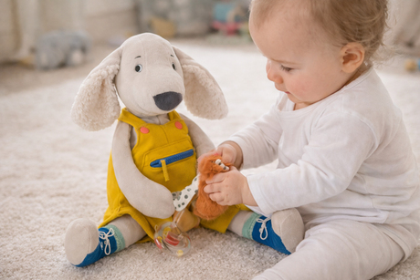 Child playing with a plush toy on a carpeted floor